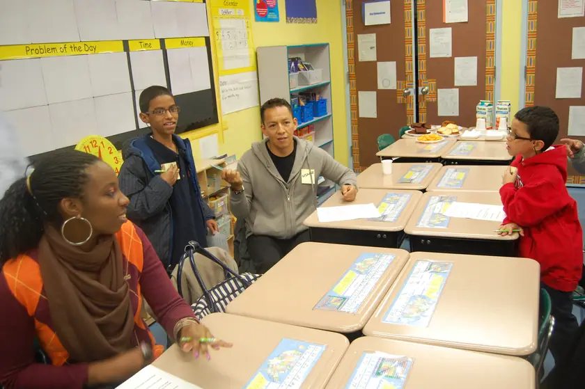 A mentor with her mentees at the tables