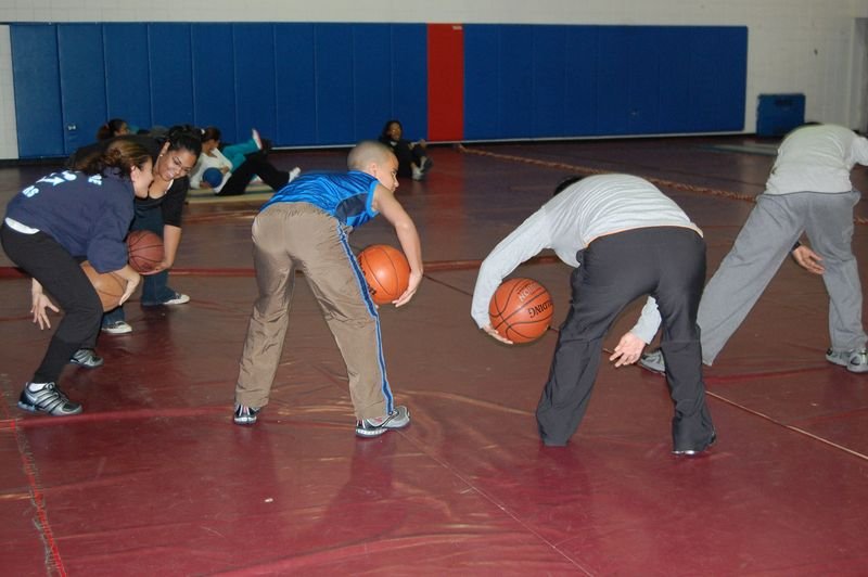 Mentees running a basketball drill in the school gym.