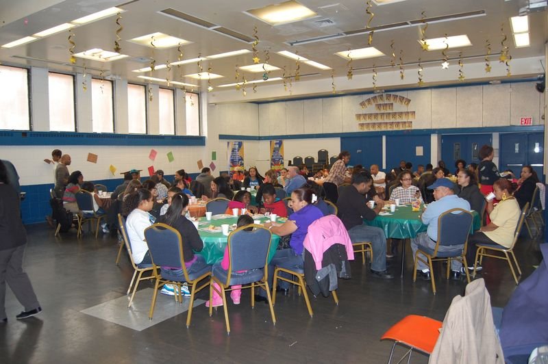 A community hall filled with families at a BOOM event.