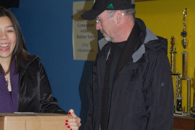 A man receives a large cardboard donation box inside the programme office.