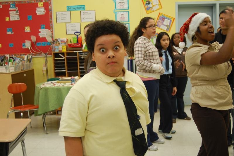 A mentee pulling a face for the camera with the holiday party going on behind.