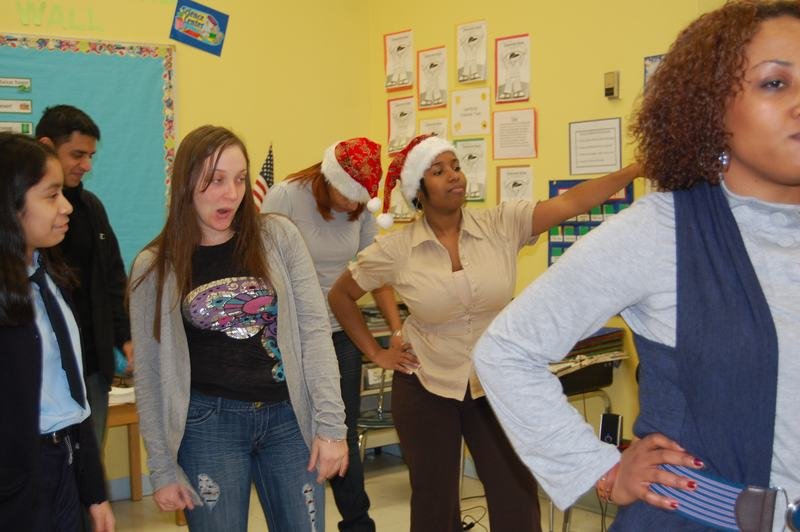 Staff members and mentees dancing together at the classroom holiday party.