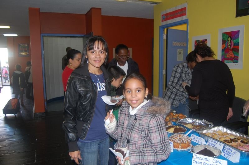 Mentees and families gather around the refreshment table at a BOOM celebration.