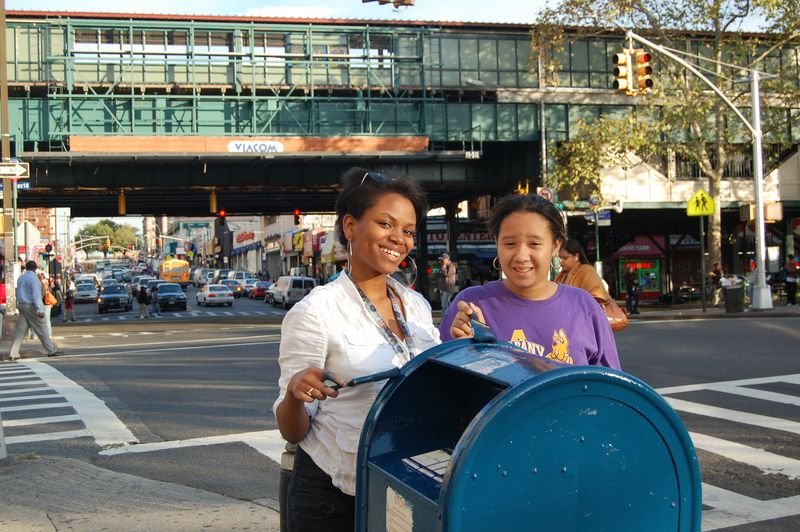 A mentor and her mentee repainting a mailbox on a Bronx street corner.