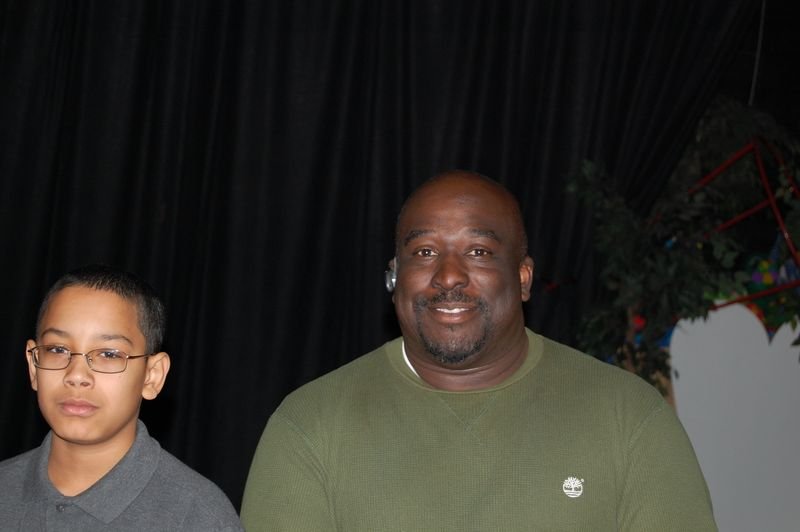 A BOOM mentee stands beside his adult male mentor at a programme event.