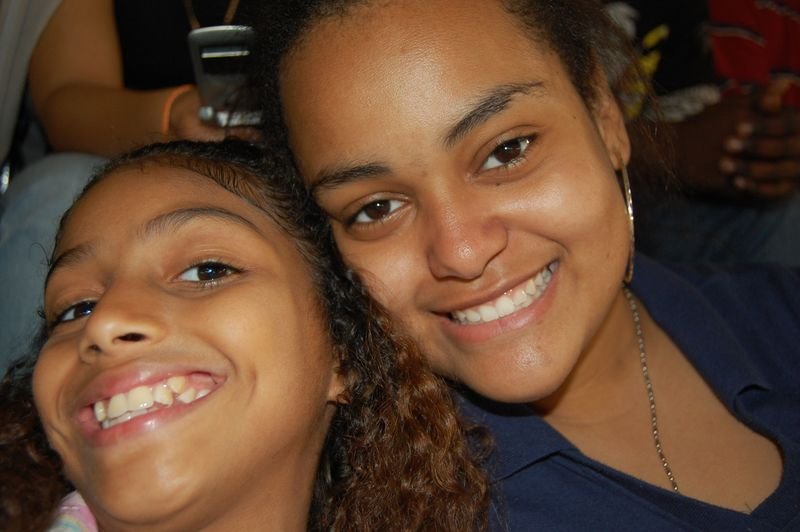 A mentor and her young mentee laughing together, heads close.