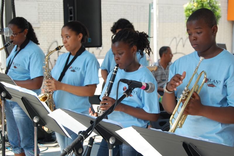 Young people from the programme playing saxophone, clarinet and trumpet together.